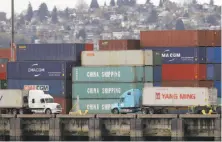  ?? Ted S. Warren / Associated Press ?? Trucks pass China Shipping cargo containers stacked at the Port of Seattle. Proposed tariffs have not yet gone into effect.