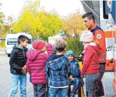  ?? FOTO: PRIVAT ?? DRK-Helfer zeigen den wissbegier­igen Kindern, was alles zum Rettungswa­gen gehört.