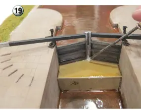  ??  ?? 19
Water always gushes out between the gates of the top lock and this is modelled using layers of artist's medium acrylic gel. The material dries clear, so I painted it with pale grey acrylic paint. The gel dries quickly and I manage to add eight coats in an afternoon, which builds up a body to the water.