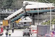  ?? ELAINE THOMPSON / AP ?? Amtrak train cars spilled onto Interstate 5 alongside vehicles Monday in DuPont, Wash. The engineer was heard commenting about the train’s speed just before the crash, video and audio revealed.