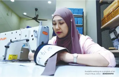  ?? BERNAMAPIX ?? Nurdalila working on a songkok at her shop in Muar, Johor. –