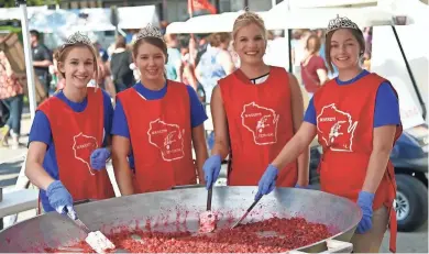  ??  ?? Cranberry Festival royalty cook up cranberrie­s for serving over ice cream at the fest in Warrens.