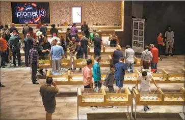  ?? Gina Ferazzi Los Angeles Times ?? SHOPPERS BROWSE cannabis products at Planet 13, a massive store that opened this month in Las Vegas.