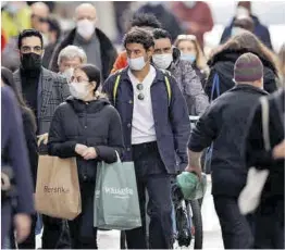  ?? Stringer / Reuters ?? Ciudadanos con mascarilla, ayer, en una calle de París.