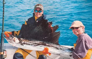  ??  ?? Ben Brownlee, the author’s son, with a sailfish caught by his mother, Poppy, off Alligator Reef in Florida.