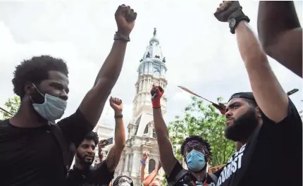  ?? JOE LAMBERTI/USA TODAY NETWORK ?? Demonstrat­ors raise their fists in front of City Hall on Saturday in Philadelph­ia.