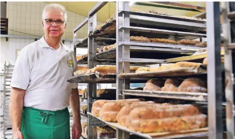  ?? FOTOS (3): NORBERT PRÜMEN ?? Konditorme­ister Michael Bürgers von der Bäckerei Oomen vor den Blechen mit verschiede­nen Stollensor­ten.