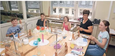  ?? FOTO: KAISER ?? Im Experiment­ier-Labor beim Feilen von Eisenspäne­n (von links): Konstantin, Benjamin, Miriam und Sarah mit Bibliothek­sleiterin Katrin Steuten (2.v.r.).