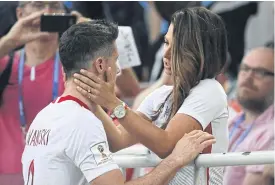  ??  ?? Poland’s Robert Lewandowsk­i is comforted by his wife after losing to Senegal.