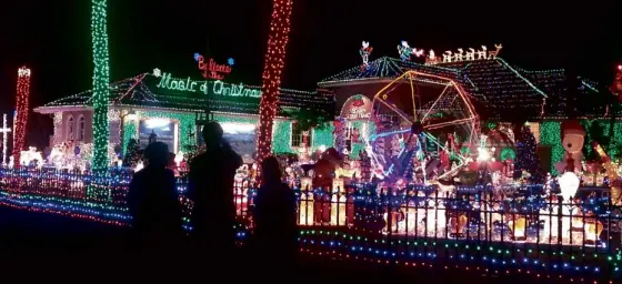  ?? REUTERS ?? HOLIDAY DISPLAY People view Kathy and Mark Hyatt’s house decorated with holiday lights in Plantation, Florida, The city is seeking to shut down the display it has deemed a commercial-size public nuisance.