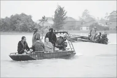  ??  ?? Residents are rescued by a boat from rising flood waters from Tropical Storm Harvey in east Houston.