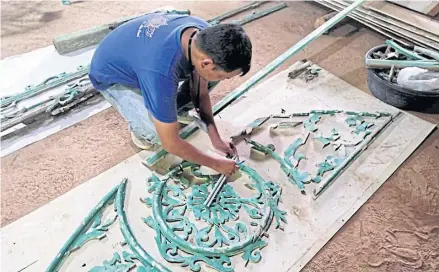  ?? PICTURE COURTESY OF FINE ARTS DEPARTMENT ?? A fine arts official is assembling debris that used to decorate the gable of ancient Bombay Burmah house that was torn down in a restoratio­n project.