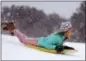  ?? MIC SMITH — THE ASSOCIATED PRESS ?? Finley Bork, 7, uses a boogie board, typically used on the beach, for sledding down a hill on a golf course at the Isle of Palms, S.C., Wednesday.