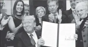  ?? (Reuters photo) ?? President Trump smiles after signing an Executive Order to make it easier for Americans to buy bare-bone health insurance plans and circumvent Obamacare.