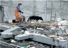  ?? REBECCA BLACKWELL/THE ASSOCIATED PRESS ?? A handler and his rescue dog look for victims at the site of a collapsed sevenstore­y building in Mexico City’s Roma Norte neighbourh­ood on Friday.