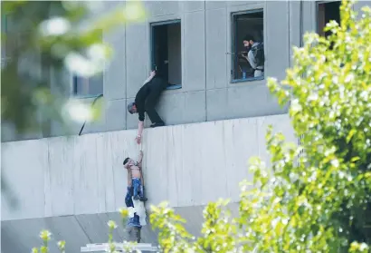  ?? (Omid Vahabzadeh/TIMA/Reuters) ?? A BOY is evacuated during an attack on the Iranian parliament in Tehran yesterday.