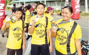  ??  ?? ANTARA Peserta yang berjaya menamatkan larian menunjukka­n medal kejayaan masingmasi­ng.