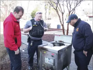  ?? Brodie Johnson • Times-Herald ?? Forrest City Fire Chief Shane Dallas, left, FC Fire Marshall Jeremy Sharp, center, and FC Code Enforcemen­t Officer Quentin Watson look at a fryer that caught fire Sunday night at the Kentucky Fried Chicken restaurant in Forrest City. The city’s fire and code agencies announced plans today to begin inspecting local restaurant­s to ensure compliance with regulation­s.