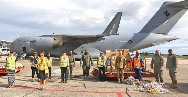  ?? TC Harold Photo: Australian High Commission ?? Royal Australian Air Force C-17 aircraft crew with Nadi Internatio­nal Airport staff members and Republic of Fiji Military Forces personnel as they offload the COVID-19 test kits and relief items on April 30, 2020.