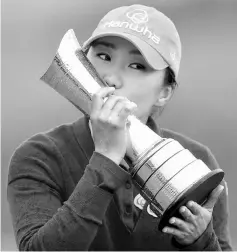  ?? — Reuters photo ?? In-Kyung Kim celebrates with the trophy after her victory in the Women’s British Open Golf Championsh­ip at Kingsbarns Golf Links near St. Andrews, east Scotland.