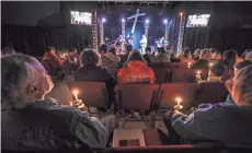  ?? MICHAEL CLEVENGER/LOUISVILLE COURIER JOURNAL ?? The members of Impact Church light candles and sing “Amazing Grace” during a service in remembranc­e of the two killed and 17 injured during a shooting Tuesday at Marshall County High School.