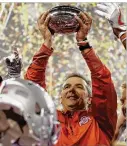  ?? PRESS MICHAEL CONROY / ASSOCIATED ?? Ohio State coach Urban Meyer holds the trophy after Ohio State defeated Wisconsin 27-21 in the Big Ten championsh­ip game.