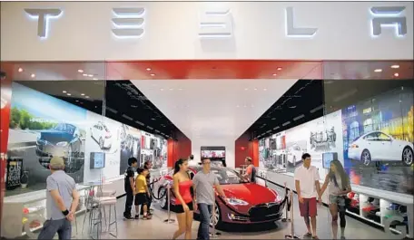  ?? Joe Raedle Getty Images ?? TESLA’S first-quarter cash drain totaled about $1 billion, up from $276.8 million in the previous quarter. Above, a Miami showroom.