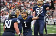  ?? PAUL DICICCO — FFOR THE NEWS-HERALD ?? Kirtland’s Mason Sullivan, center, celebrates with linemen Kiki Grman (50) and T.J. Green (52) after a touchdown in the Division V state final Nov. 21 against Ironton.