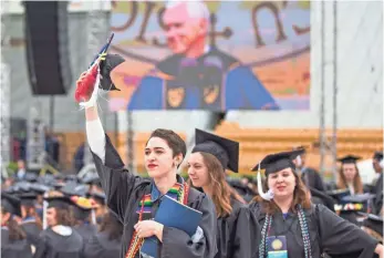  ?? ROBERT FRANKLIN, SOUTH BEND TRIBUNE, VIA AP ?? Notre Dame graduates walk out of Notre Dame Stadium on Sunday in protest as Vice President Pence speaks during the 2017 commenceme­nt ceremony in South Bend, Ind.