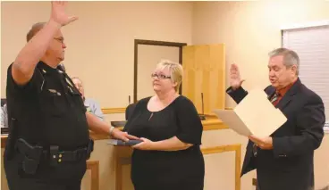  ?? Kevin Myrick/SJ ?? Chief Marc Riley of the Aragon Police Department takes the oath of office from Aragon Municipal Court Judge Terry Wheeler while Lisa Riley holds the bible.