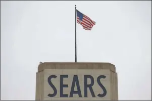  ?? The Associated Press ?? SEARS BANKRUPTCY: An American flag flies above a Sears department store sign, Monday in Hackensack, N.J. Sears filed for Chapter 11 bankruptcy protection Monday, buckling under its massive debt load and staggering losses.