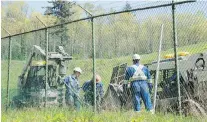  ?? JONATHAN HAYWARD, THE CANADIAN PRESS ?? Workers install new fence posts surroundin­g the Kinder Morgan property in Burnaby.