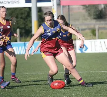  ?? ?? Kira Wilson has eyes only for the ball as she prepares to pick it up for Warragul Industrial­s youth girls. Wilson was named her side’s best player for the day.