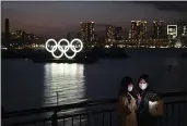  ?? JAE C. HONG — THE ASSOCIATED PRESS FILE ?? Two women take a selfie with the Olympic rings in the background in the Odaiba section of Tokyo on Thursday, March 12, 2020.