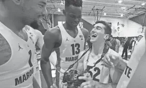  ?? MARK HOFFMAN / MILWAUKEE JOURNAL SENTINEL ?? Marquette freshman Ike Eke (center) of Detroit joked around with teammates during the team's media day.