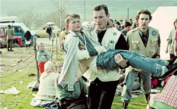  ?? ?? A 10-year-old boy is carried across the border from what is now Kosovo to Albania in 1999. The conflict between Yugoslavia, which controlled Kosovo, and the Kosovo Albanian rebels ended that year after Nato interventi­on