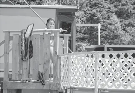  ?? NICOLE SULLIVAN/CAPE BRETON POST ?? Paige Tucker, 10, happily cleans her family’s new pool before taking another dip with her sister and a friend on Friday.