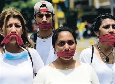  ?? RONALDO SCHEMIDT / AFP ?? Participan­ts amb la boca tapada en una de les marxes silenciose­s d’ahir a Caracas