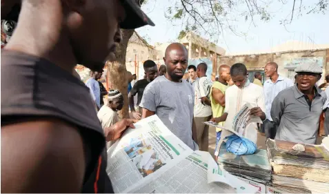  ?? | Reuters ?? NIGERIANS gather at a newspaper stand while they await the results of the presidenti­al elections in Kano, Nigeria, yesterday.
