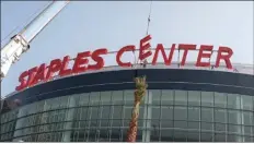  ?? AP file photo ?? Constructi­on workers
put the finishing touches on the Staples Center sign outside the arena in Los Angeles on Sept. 16, 1999. Starting Christmas Day, the home of the NBA’s Lakers and Clippers, the NHL’s Kings and the WNBA’s Sparks will change its name to Crypto.com Arena.