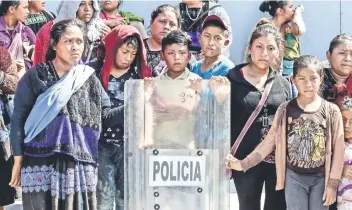  ??  ?? Los indígenas fueron replegados con escudos de los cuerpos policiacos en las inmediacio­nes del Congreso del estado.