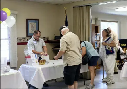  ?? PHOTOS BY ALIAH KIMBRO — THE MORNING JOURNAL ?? North Ridgeville Fire Station volunteer Tim Linder assists patrons in signing up for a raffle.