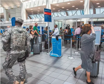  ?? CITIZEN NEWS SERVICE PHOTO BY DAVID WILLIAMS ?? Travelers at the Delta Air Lines ticket counter at LaGuardia Airport in New York in 2017.