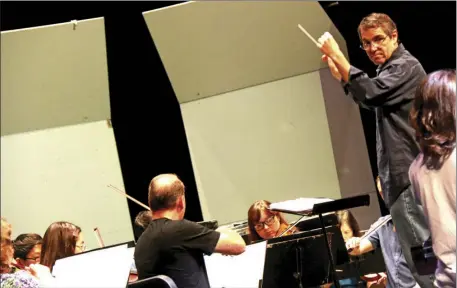  ?? WILLIAM ROLLER PHOTO ?? Matthew Busse (with baton) conducts the Imperial Valley Symphony rehearsal Saturday prior to the final performanc­e of the 43rd season in El Centro.