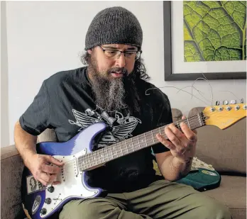  ?? RYAN TAPLIN ■ THE CHRONICLE HERALD ?? Stephen Richardson jams on his guitar in his hotel room in downtown Halifax on Thursday, March 21, 2024. Richardson, who is originally from Cape Breton, teaches music at Ecole St. Joseph in Yellowknif­e. He is in the running for a Musicounts Teacher of the Year at Sunday’s Juno Awards. This is the third time Richardson has been nominated for the award.