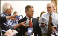  ?? PHOTOS BY HANS PENNINK — ASSOCIATED PRESS ?? Sen. Patrick Gallivan, R-Elma, center, talks with reporters as legislativ­e members work on the state budget at the state Capitol on Friday.