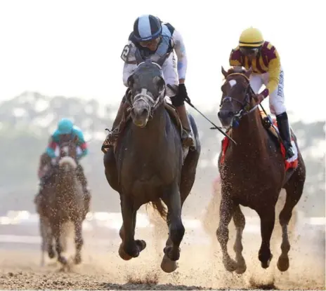  ?? AL BELLO/GETTY IMAGES ?? Jose Otriz rides Tapwrit to victory past favoured Irish War Cry in the Belmont Stakes on Saturday. Tapwrit won by two lengths.