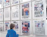  ??  ?? LEFT
A boy looks at front pages of newspapers from the day after the September 11, 2001 attacks during a visit to the Newseum.