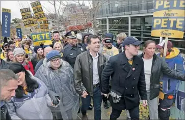  ?? Nati Harnik Associated Press ?? PETE BUTTIGIEG, center, is practicall­y tied in Iowa with Elizabeth Warren, Bernie Sanders and Joe Biden in a recent poll. Here, he leads backers to the Democrats’ Liberty and Justice event in Des Moines on Friday.