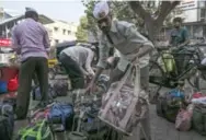  ?? ALLISON JOYCE FOR THE WASHINGTON POST ?? Lunch delivery men in Mumbai, India, known as dabbawalla­s, organize meals for delivery in February.